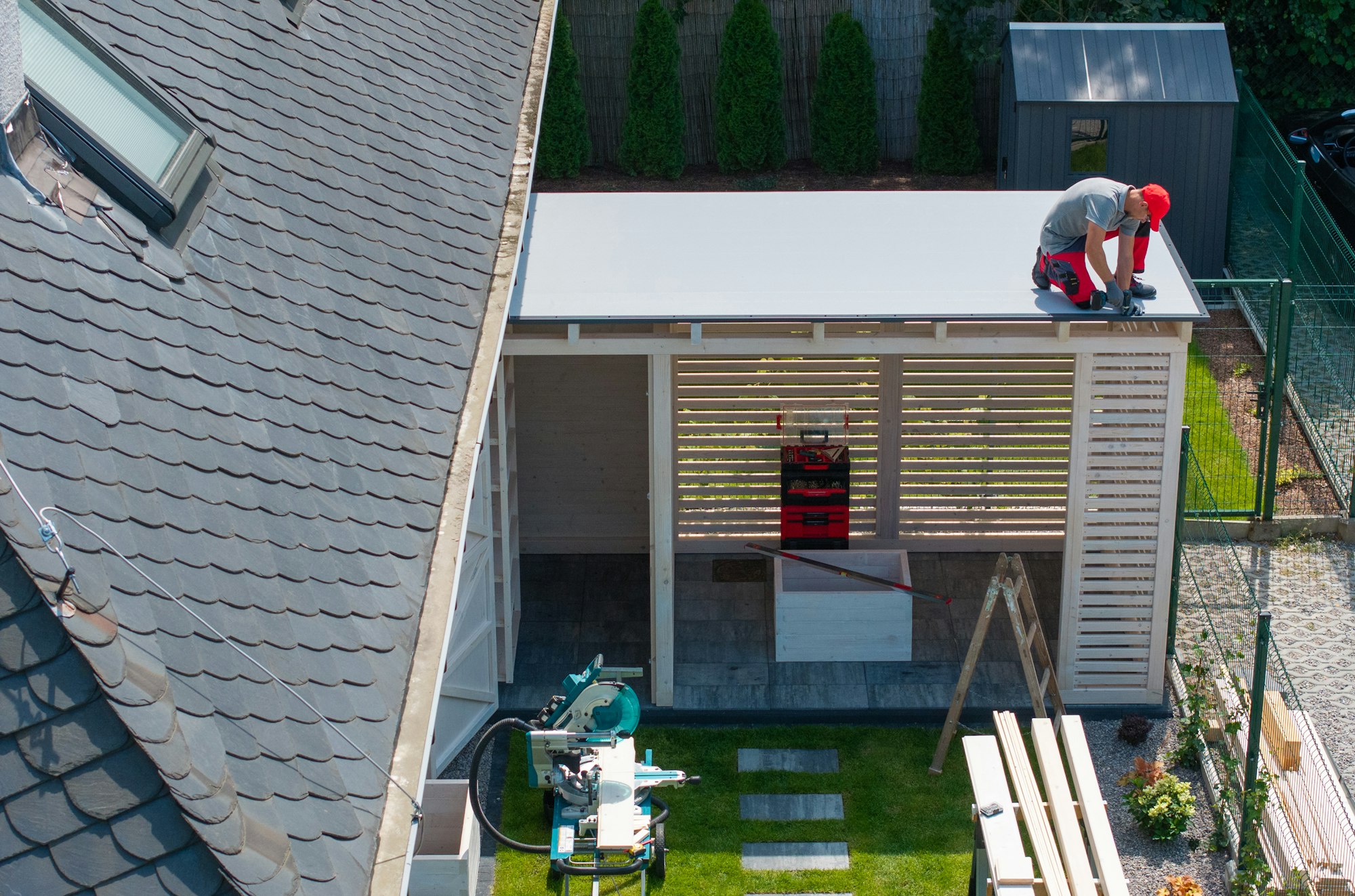 worker-installing-roof-on-patio-structure-LVNAXD8